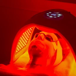 Cliente allongée sous un masque LED rouge, chez About Your Skin à Bruxelles