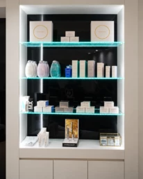 Vitrine de produits Ingrid Millet avec étagères en verre éclairées et coffrets de soin